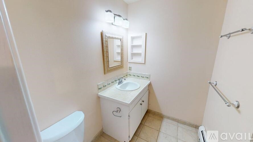A small bathroom with a toilet, sink, and mirror.