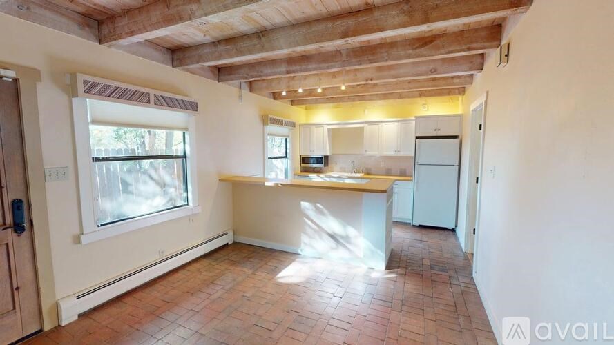 A kitchen with a wooden ceiling and a tiled floor.