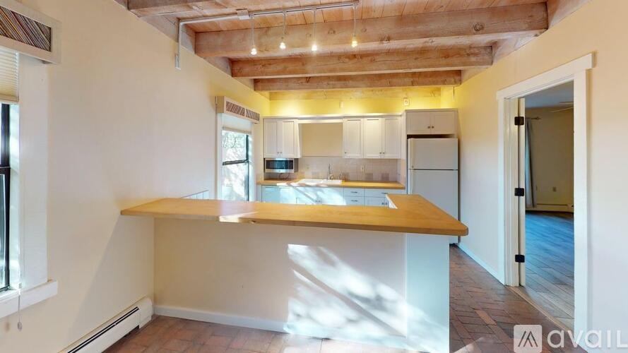 A kitchen with wooden ceiling and white walls.