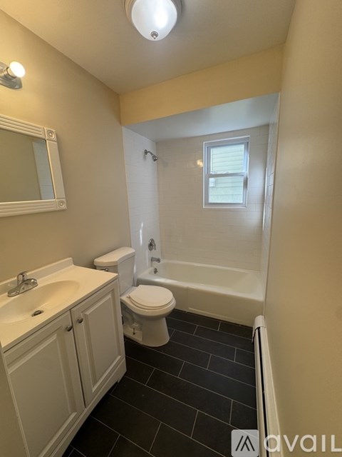 A bathroom with a toilet, sink, and bathtub.