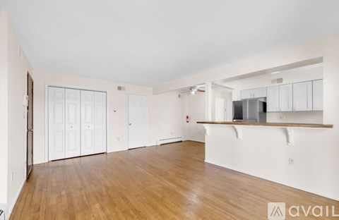 A spacious room with wooden floors and white walls.