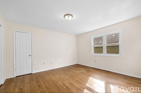 A room with a white door and a window with blinds.