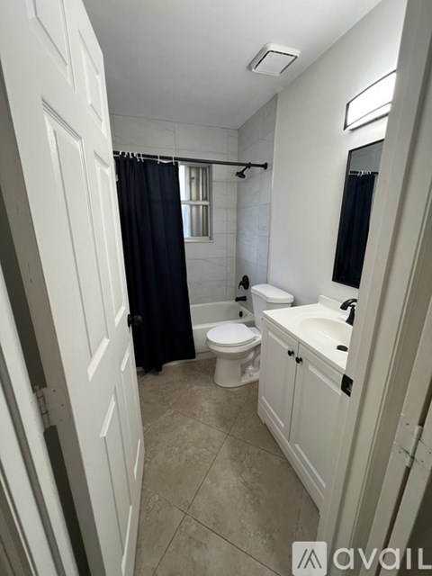 A bathroom with a toilet, sink, and shower.
