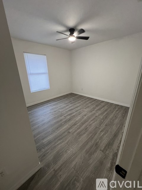 A room with a ceiling fan and a window.