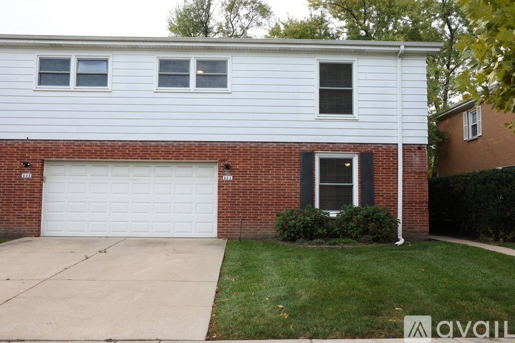 A house with a white garage door and a brick wall.