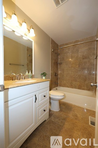 A bathroom with a toilet, sink, and a mirror.