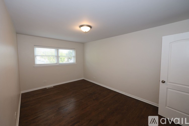 A room with a white door and a window with blinds.