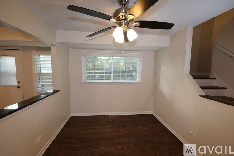 A room with a ceiling fan and a window with blinds.