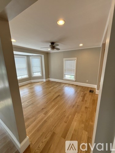 A room with wooden floors and a ceiling fan.