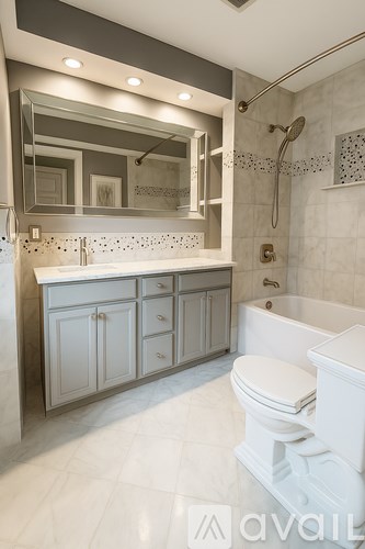 A bathroom with a white toilet and a white bathtub.