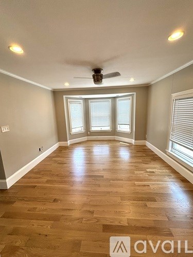 A room with wooden flooring and a ceiling fan.