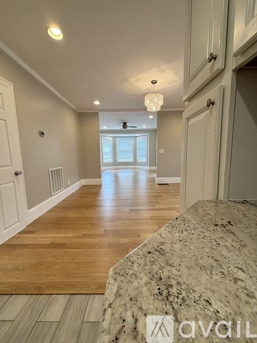 A spacious room with wooden flooring and a marble countertop.