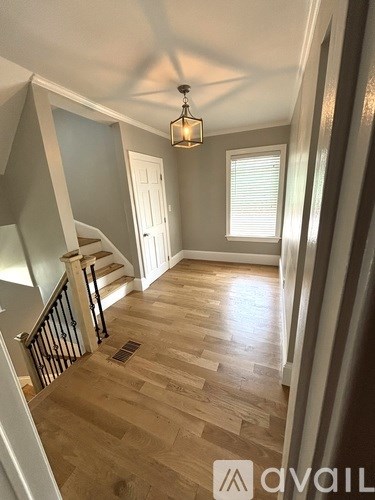 A hallway with wooden floors and a light fixture.