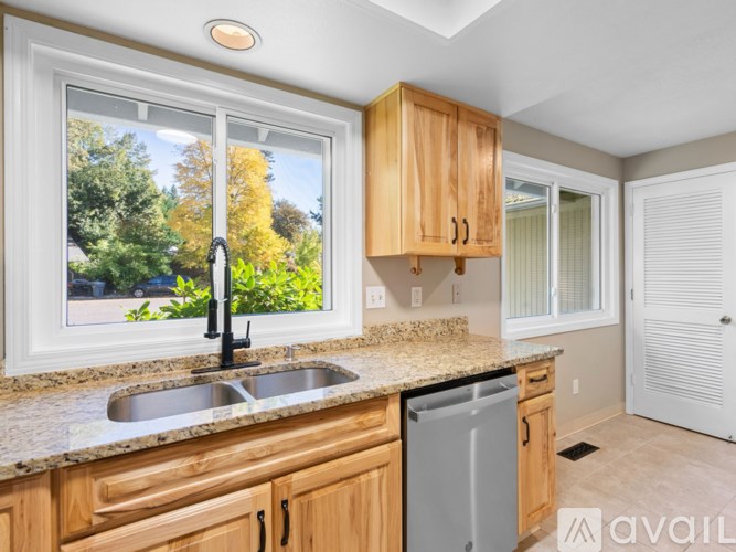 A kitchen with wooden cabinets and a granite countertop.