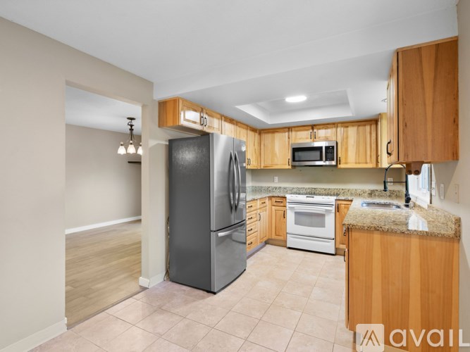 A kitchen with wooden cabinets and a black refrigerator.