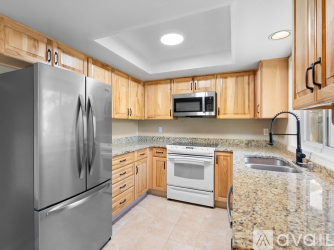 A kitchen with a granite countertop and stainless steel appliances.