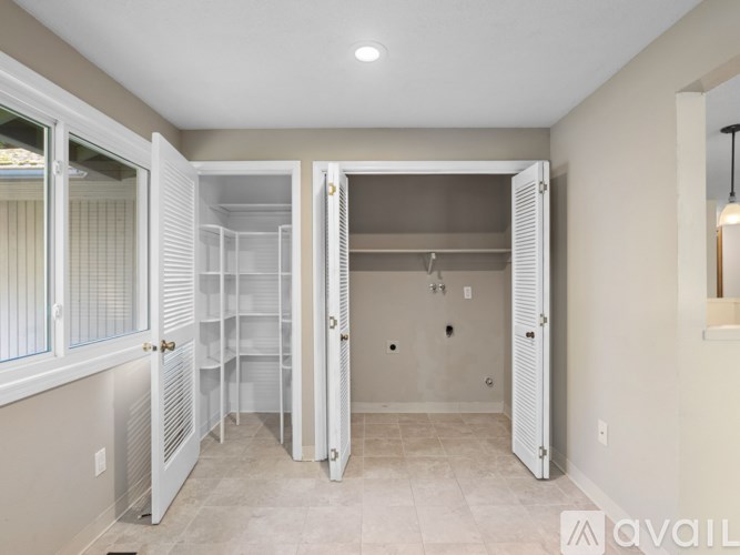 A spacious kitchen with white cabinets and a walk-in shower.