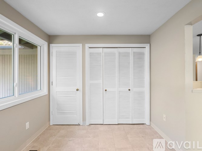 Closet with white doors in a room.