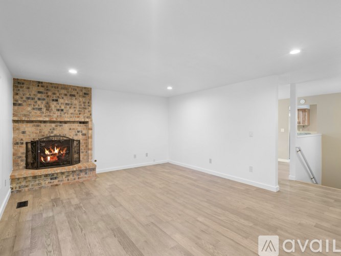 A room with a fireplace and wooden flooring.