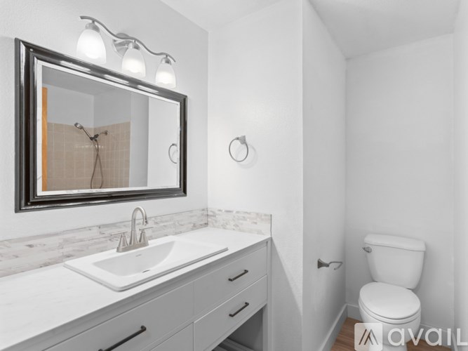 A bathroom with a sink, mirror, and toilet.