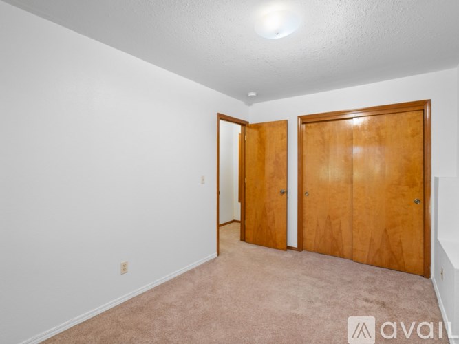 A room with two wooden doors and carpeted floor.