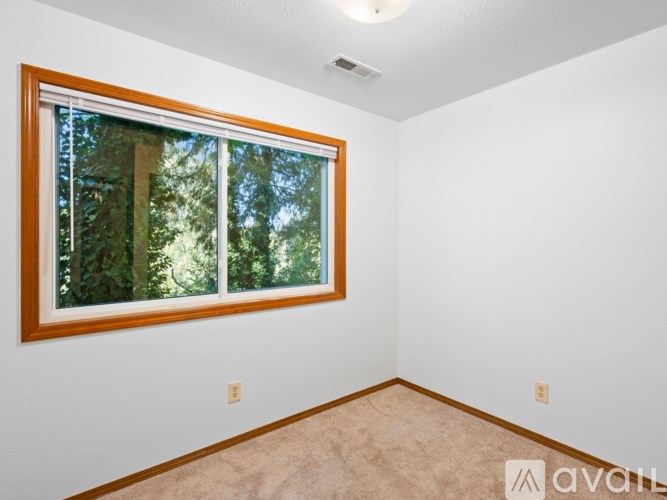 A room with a window showing trees outside.