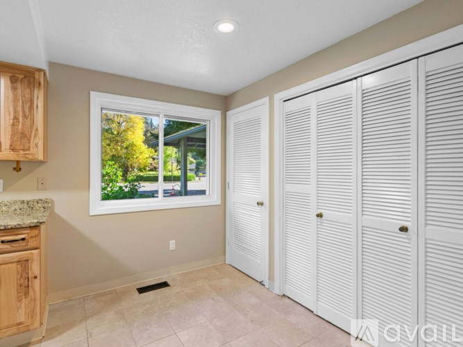 A room with white cabinets and a window showing an outdoor view.
