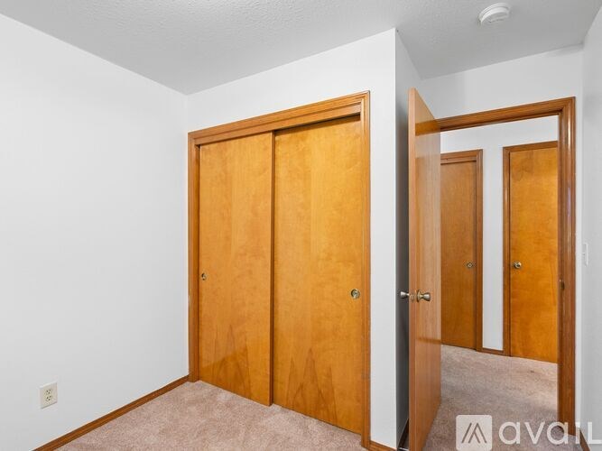 A room with two wooden doors and a carpeted floor.