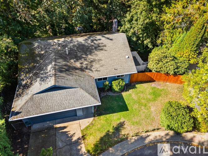 A house with a grey roof surrounded by greenery.