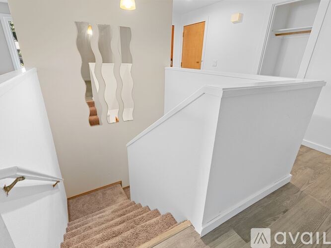 A staircase with a beige carpet and white walls.