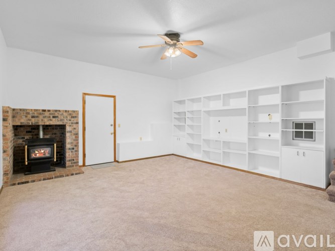 A spacious living room with a fireplace and built-in shelves.