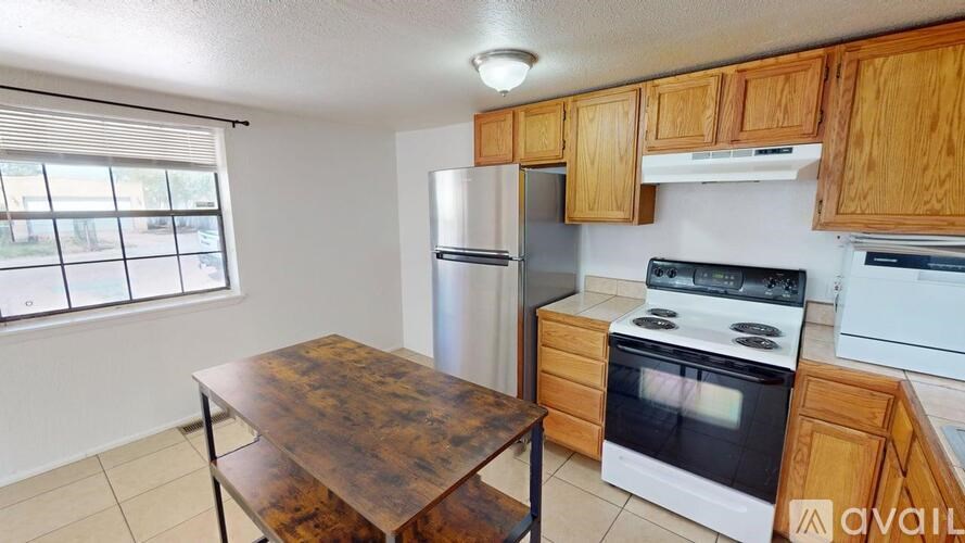 A kitchen with wooden cabinets and a stove top oven.