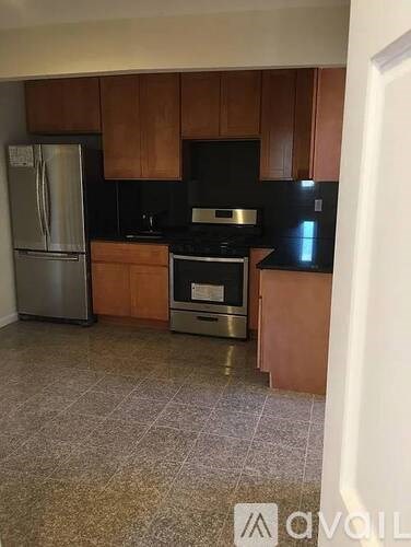 A kitchen with a refrigerator, oven, and microwave.