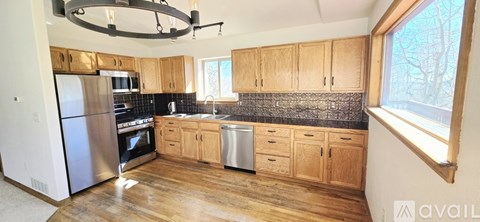 A kitchen with wooden cabinets and a stainless steel refrigerator.