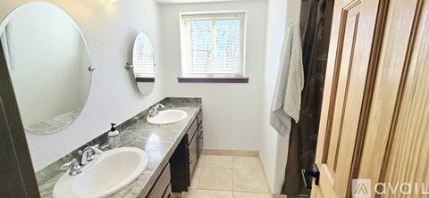 A bathroom with two sinks and a large mirror.
