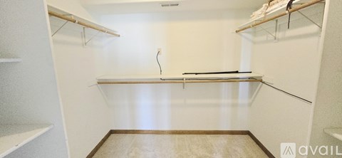 A walk-in closet with shelves and a bench.