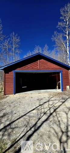 A red barn with a black door and a blue trim.