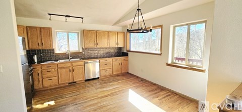 A kitchen with wooden cabinets and a black countertop.