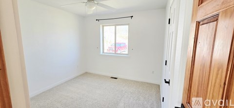 A room with a window and a ceiling fan.