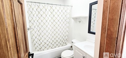 A small white bathroom with a toilet, sink and shower.