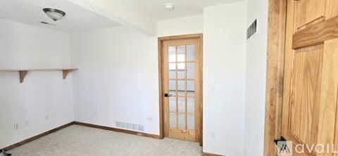 A room with a wooden door and a window.