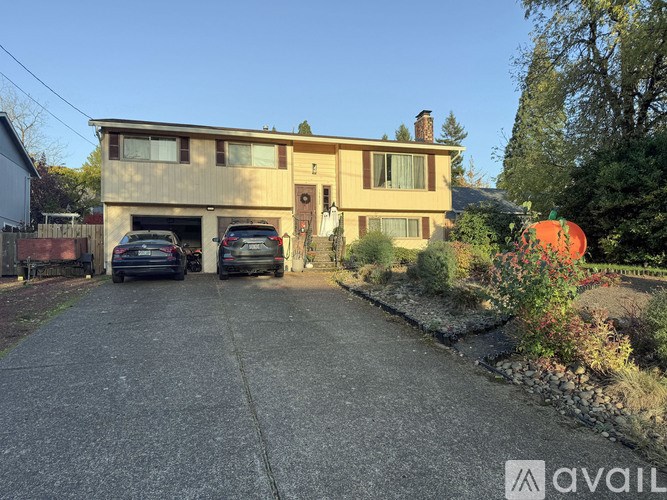A house with a driveway and two cars parked in front.