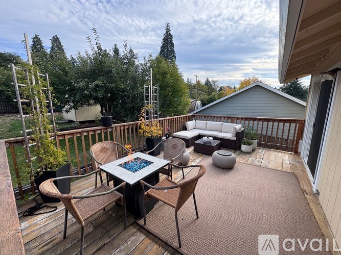 A patio with a table and chairs is surrounded by trees.