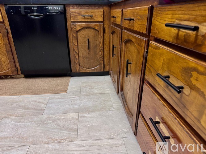 A kitchen with wooden cabinets and a black oven.