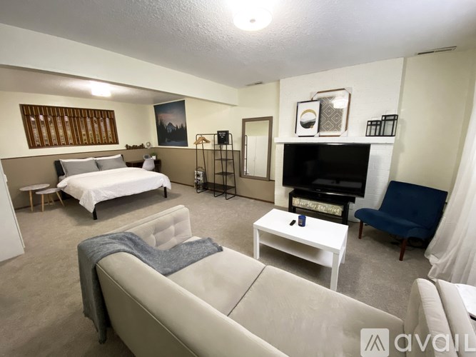 A living room with a white couch and a fireplace.