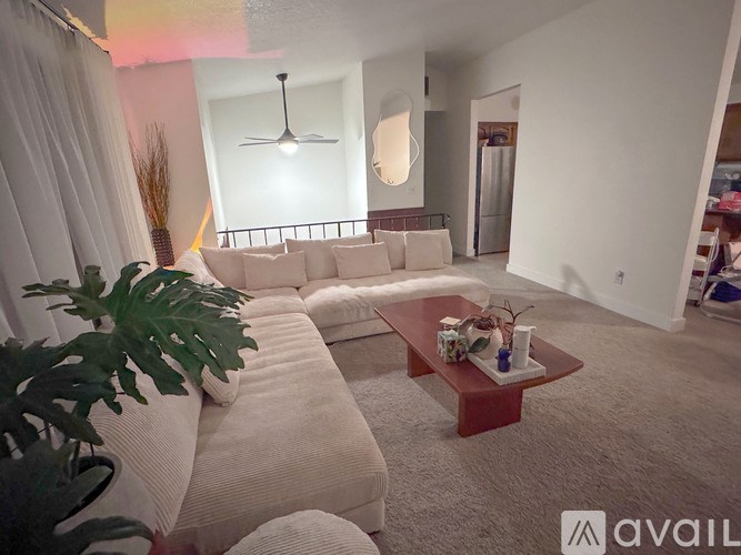 A living room with a white couch and a coffee table.
