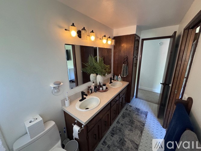 A bathroom with a toilet, sink, and mirror.