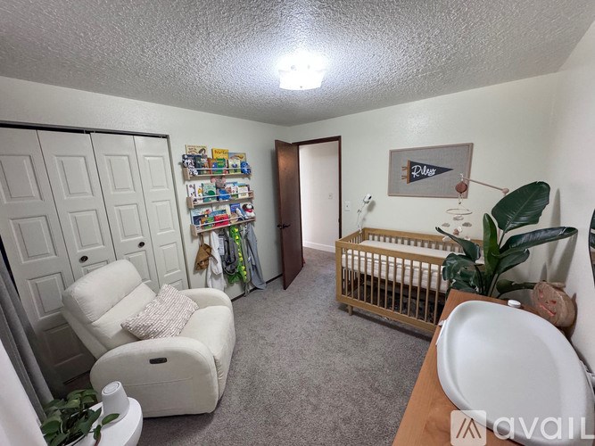 A baby's room with a crib and a chair.