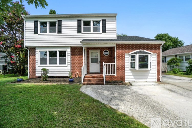 A two-story house with a red brick front and white siding.