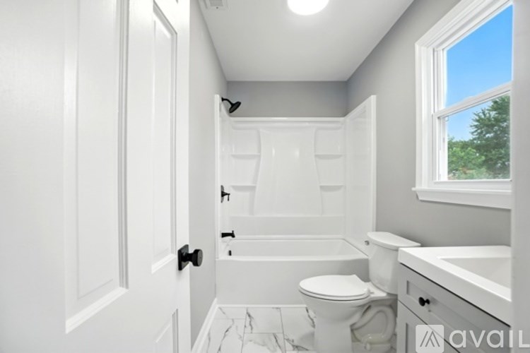 A white bathroom with a toilet, sink, and bathtub.